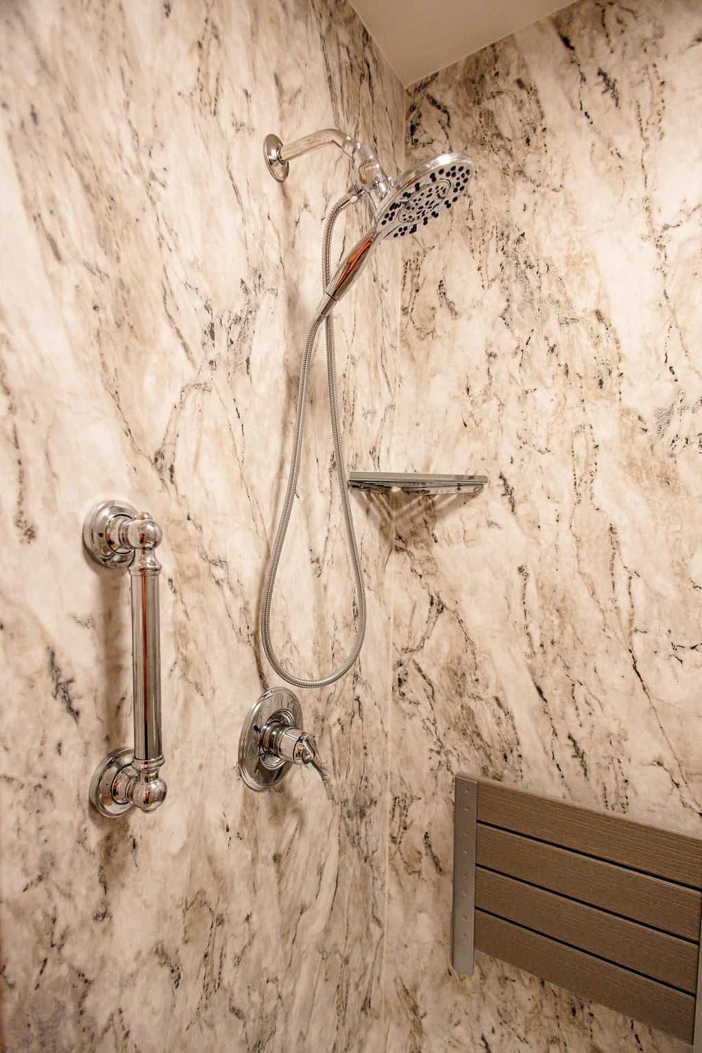 LatashaCarrawayPhotography-3337 closeup of marble shower fixtures, grab bar, and corner shelf