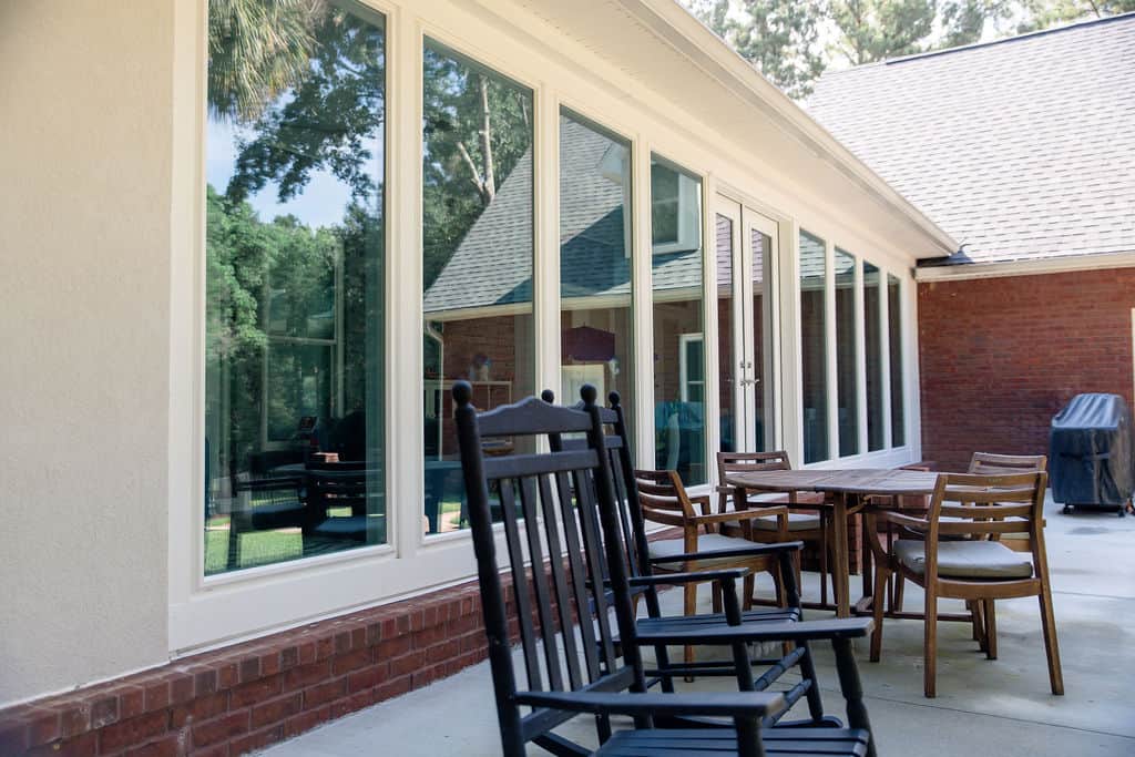 LatashaCarrawayPhotography-3384 angled view of glass sunroom and wooden patio furniture