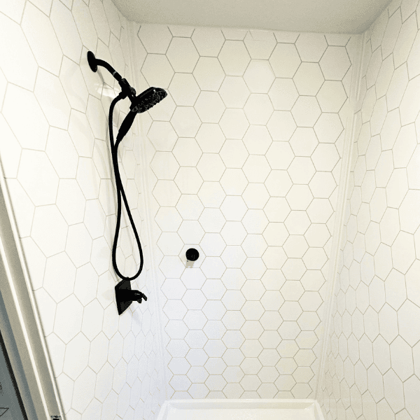 large marble shower with multiple grab bars