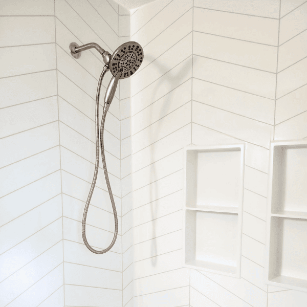 large marble shower with multiple grab bars