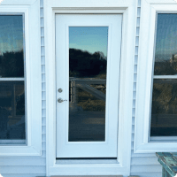 New white professional-grade exterior door with glass panel, perfect for home upgrades and outdoor living enhancements in NWFL.