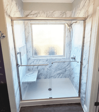 Stunning marble walk-in shower with glass enclosure, perfect for bathroom remodeling and upgrade projects by HTC Pros in NWFL.