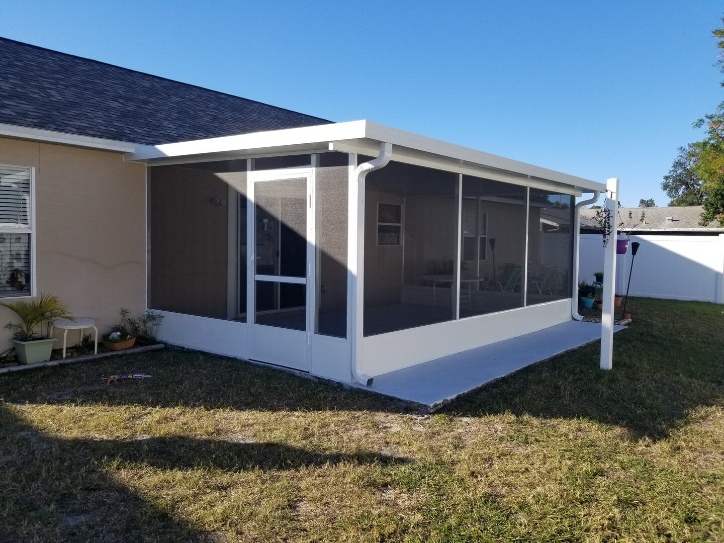 screen room slide 6 Enclosed backyard patio screen room with aluminum frame and mesh screens for outdoor relaxation.