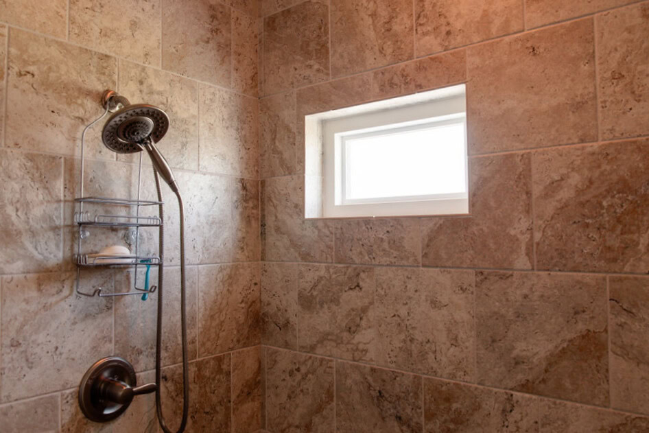 2e096475-68c3-4484-a2e0-3b3c171aab6e Large walk-in shower with detachable wand and small window- detail shot