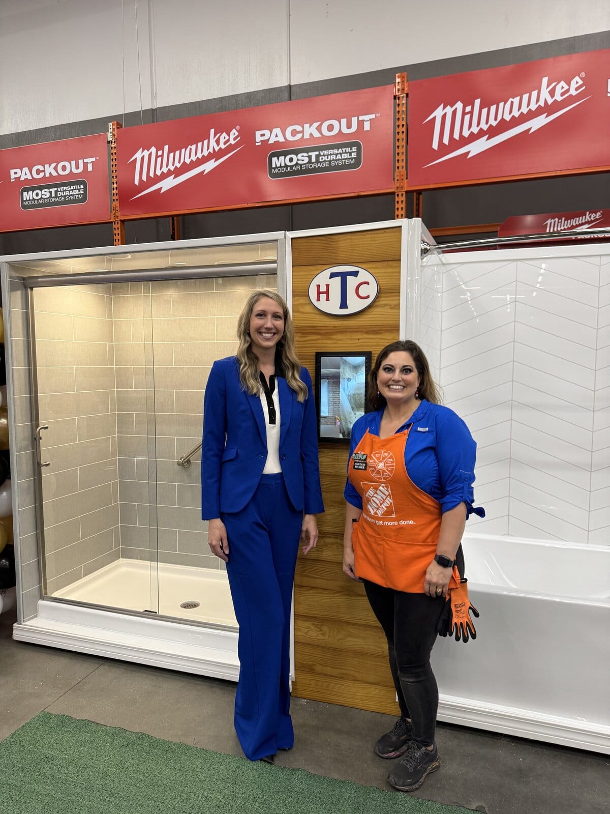 Hometown Contractors executive and Home Depot Manager posing for photo in-front of HTC Showers and Bathtubs at The Home Depot in Pace, FL 11/2025