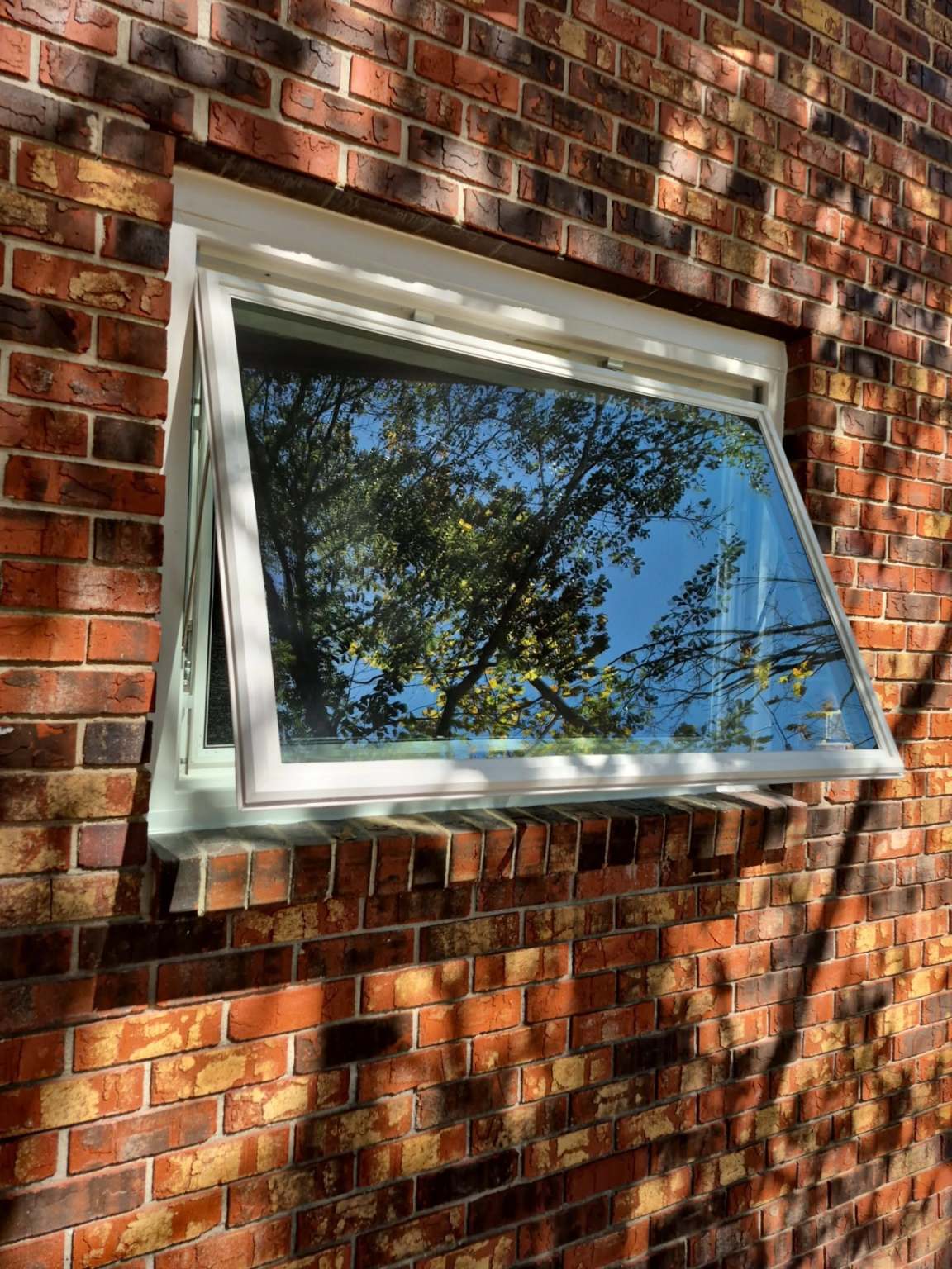 Gallery Awning Window Angled photograph of an awning window on the side of a brick home