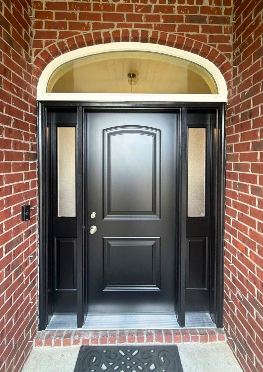 Gallery Black Front Door Black front entry door with red brick surrounding and silver door handle. Black sidelites on either side of door and curved window above.