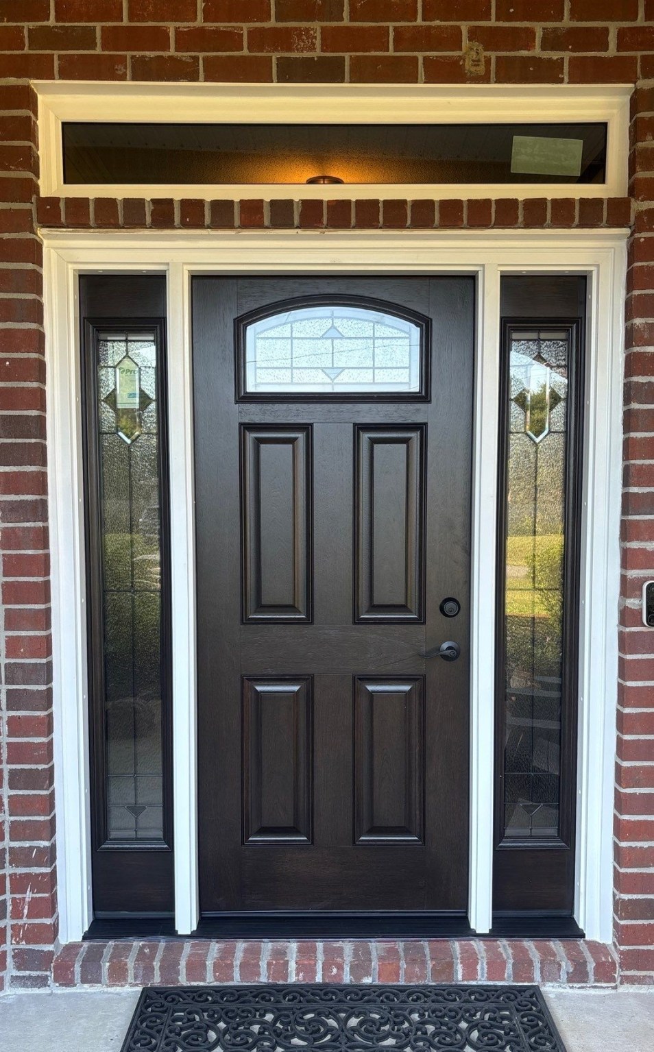 Gallery Black Front Door1 Black front entry door with black trimmed sidelites on either side and a rectangle window above.