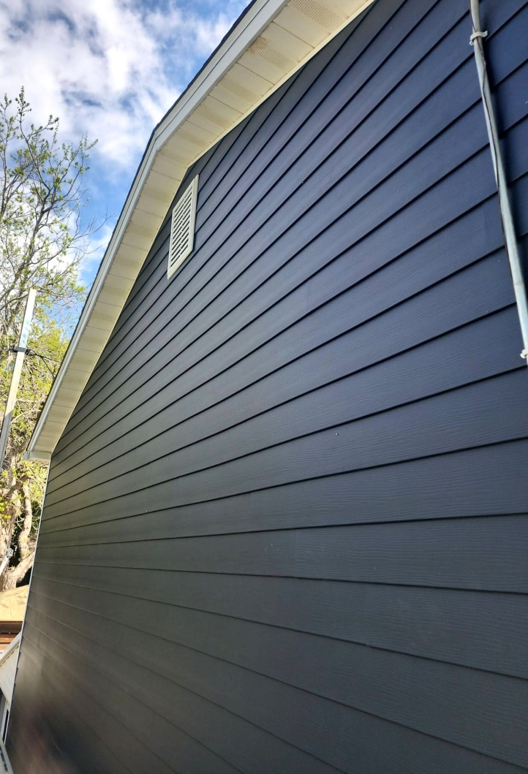 Gallery Dark Blue Siding Angled photograph of dark blue siding with white soffits