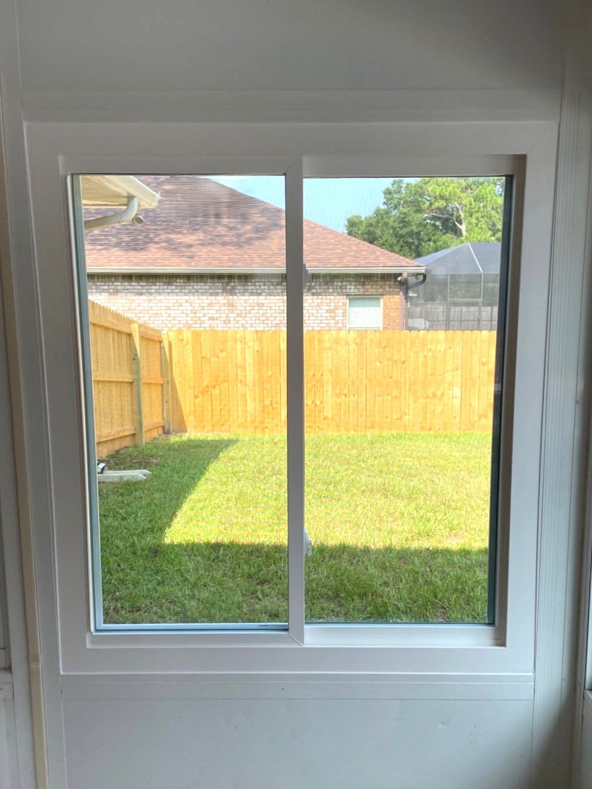 Gallery Sliding Window Sliding window with white surrounding walls and view of backyard fence
