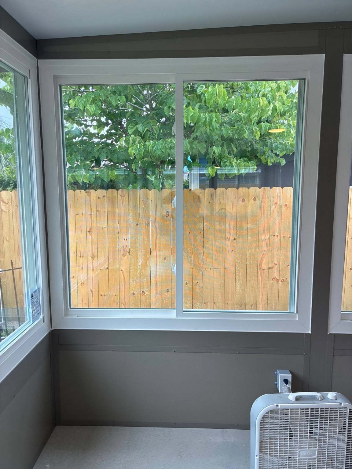 Gallery Sliding Window1 Sliding window in sunroom with a view of a fence