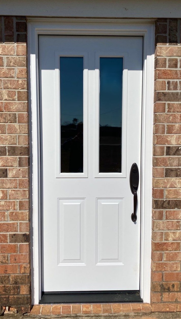 Gallery White Exterior Door White exterior door on a brick home with a black door handle and two thin window cutouts.