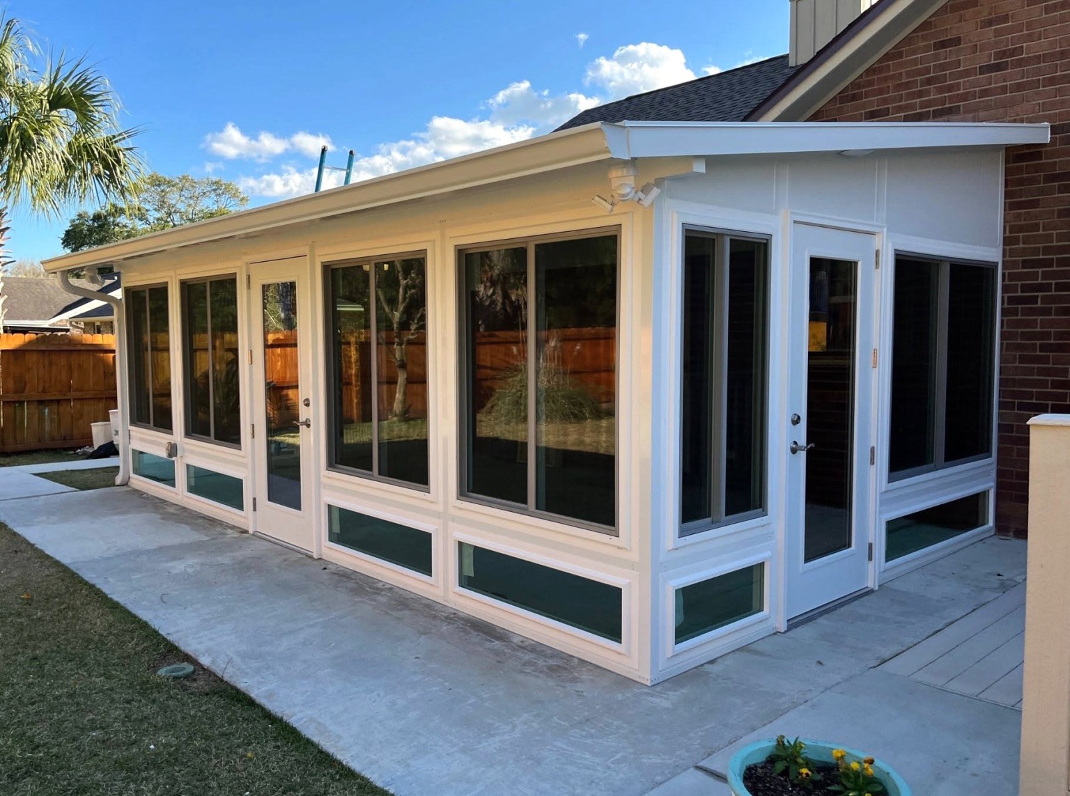 Gallery White Sunroom Angled view of a white sunroom from outside with a white door on the front and on the side of the room.