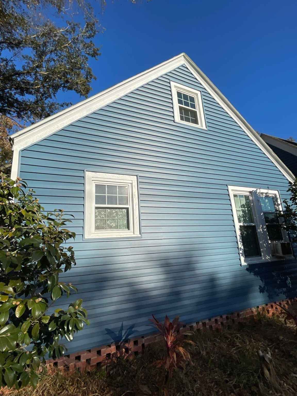 Gallery Laguna Blue Siding Ocean blue composite siding with three white-trimmed windows and white soffits