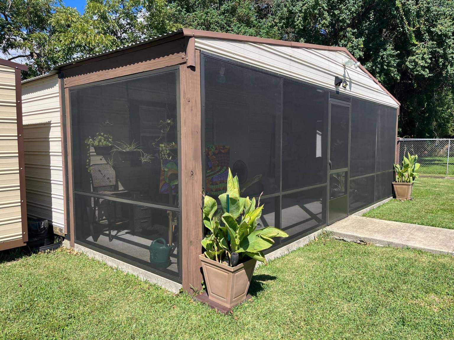 Gallery Patio Screen Enclosure Gutters Screened-in room from the outside attached to white gutters and a concrete path leading to the screen door