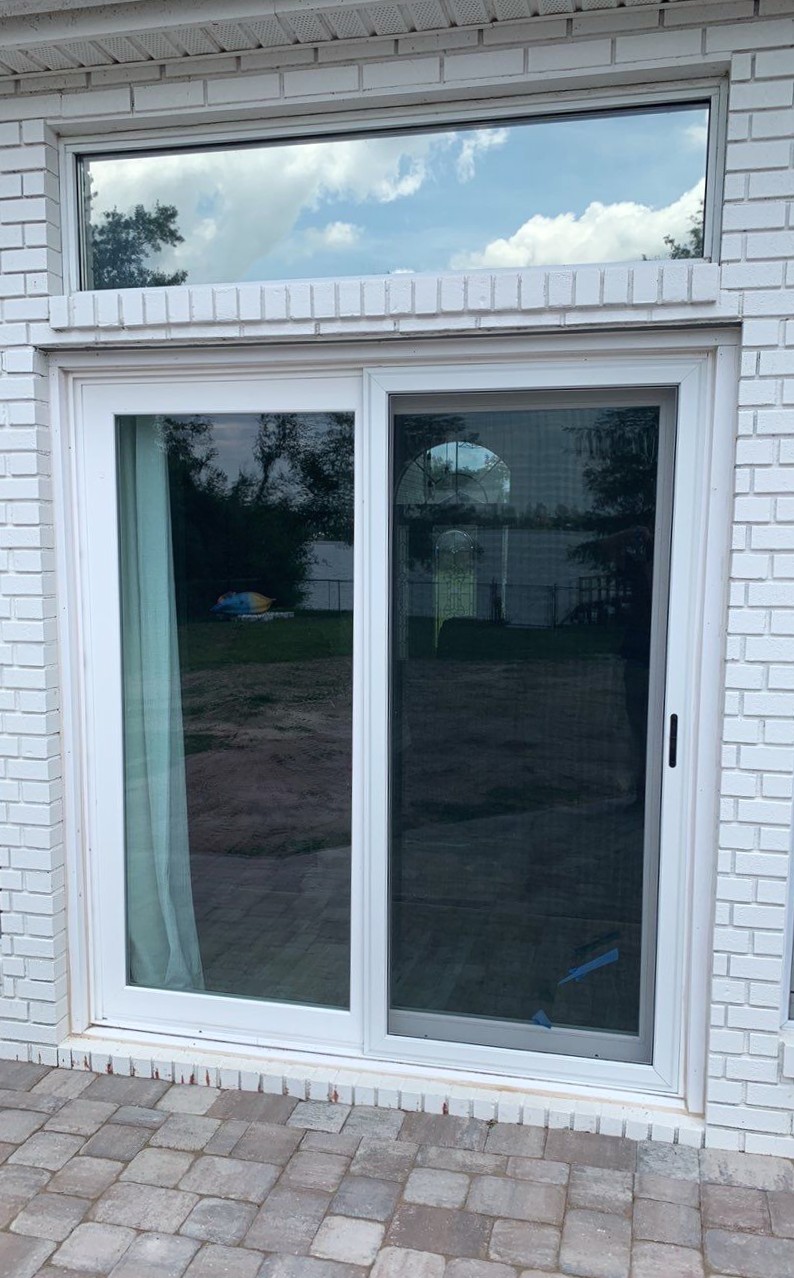Gallery Sliding Glass Doors White Brick Sliding glass door attached to a white brick home with rectangle window above door
