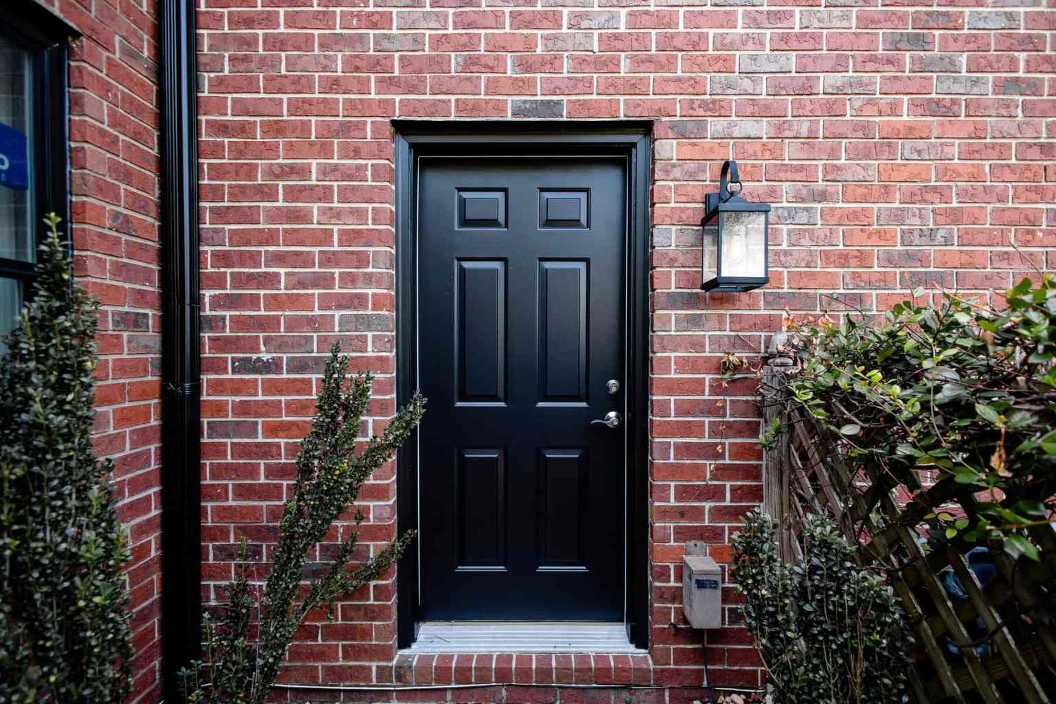 Black Exterior Door Black exterior door with silver door handle in a red brick home.