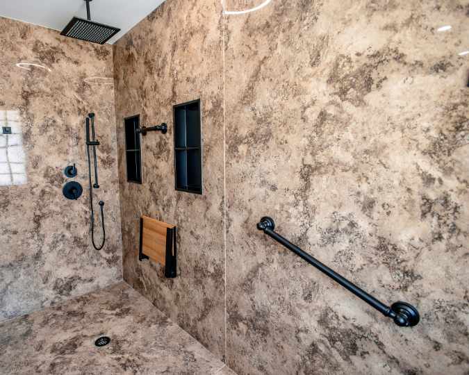 Black grab bar attached to granite-like shower walls 