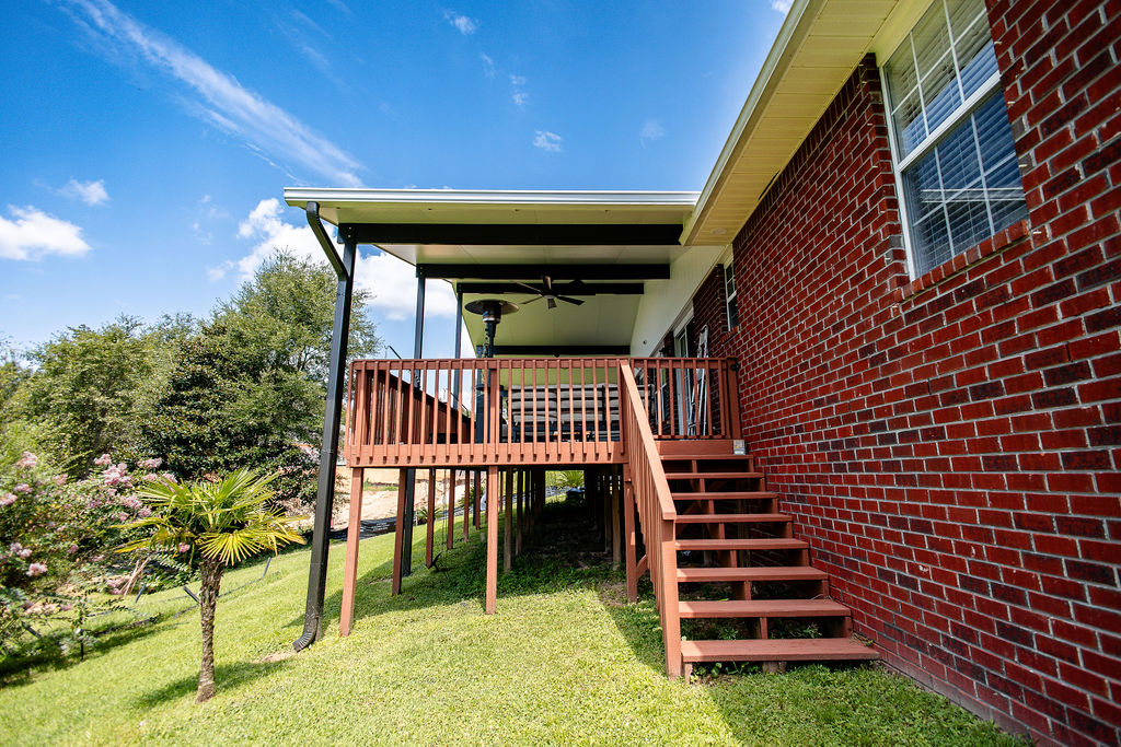 LatashaCarrawayPhotography-8708 Side view of custom patio cover installed over elevated deck attached to red brick house.