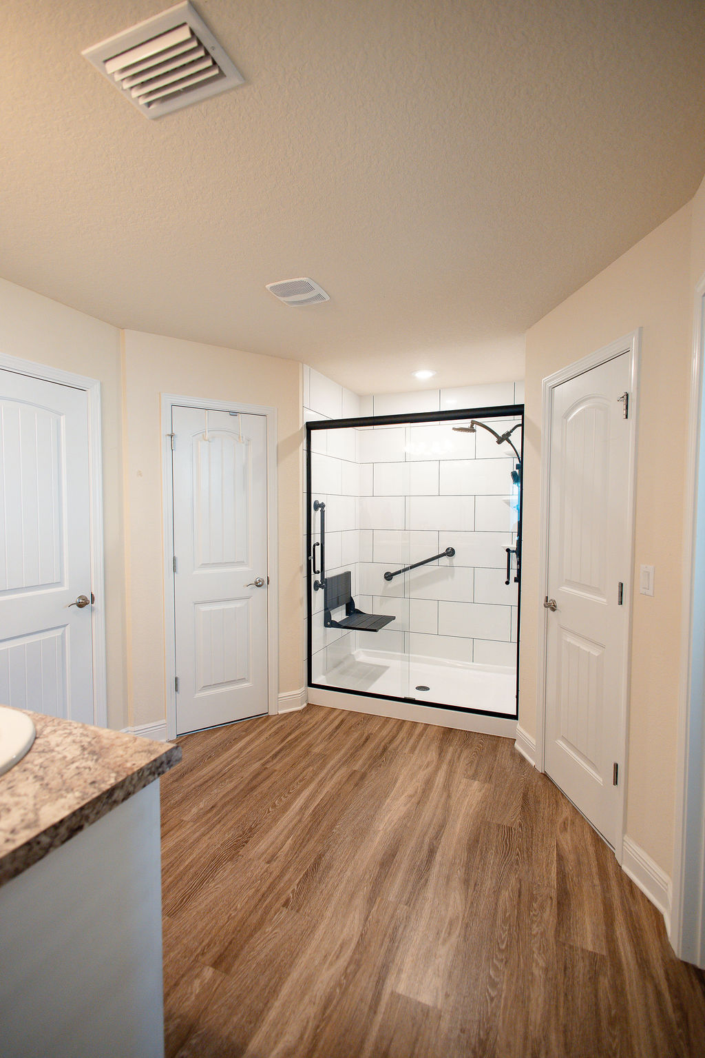 LatashaCarrawayPhotographyAFTER-8675 bathroom interior shot focused on new low-barrier shower with white subway tile surrounds and matte black accessories