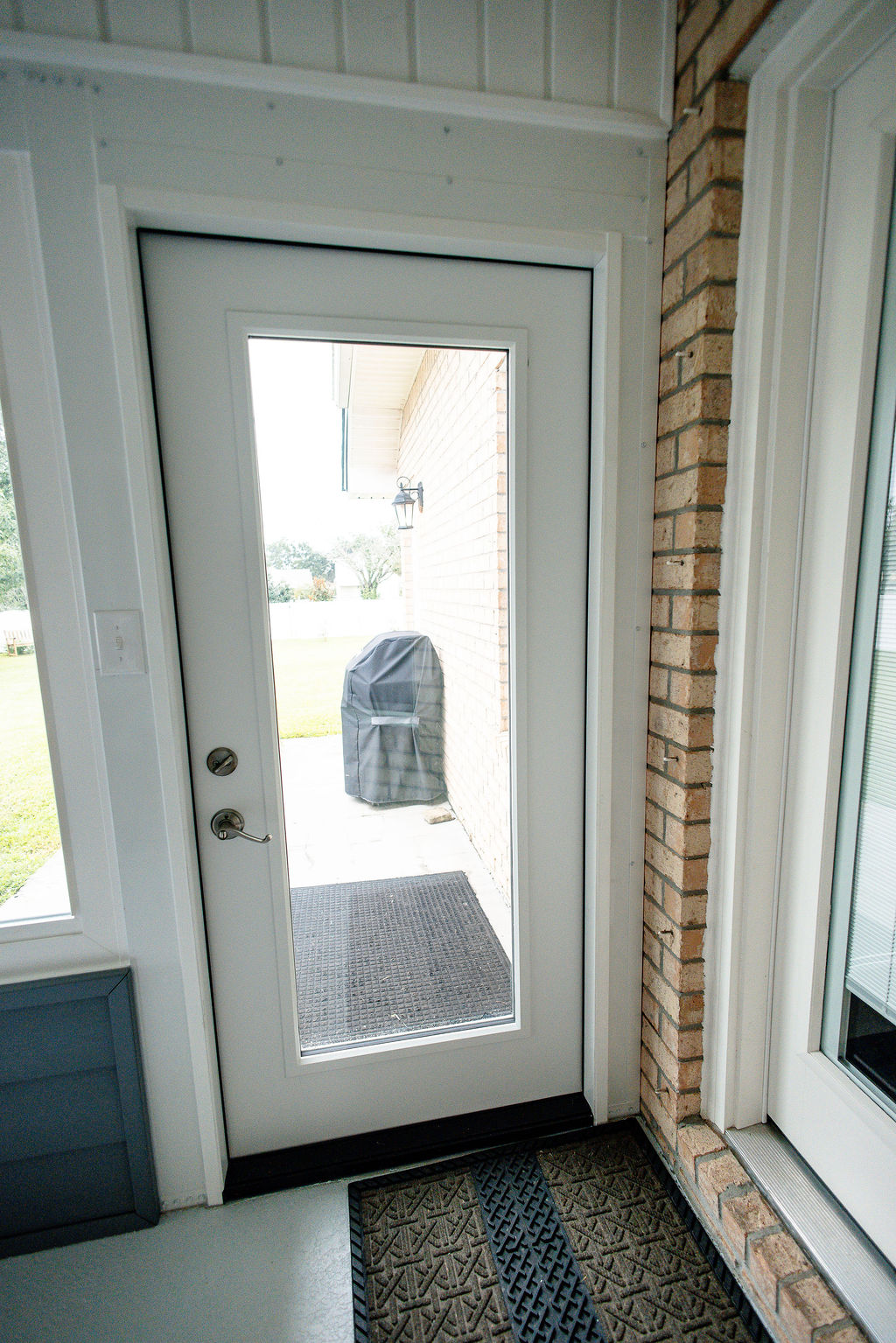 LatashaCarrawayPhotographyH.-9140 Exterior door with glass center leading out of porch enclosure into backyard.