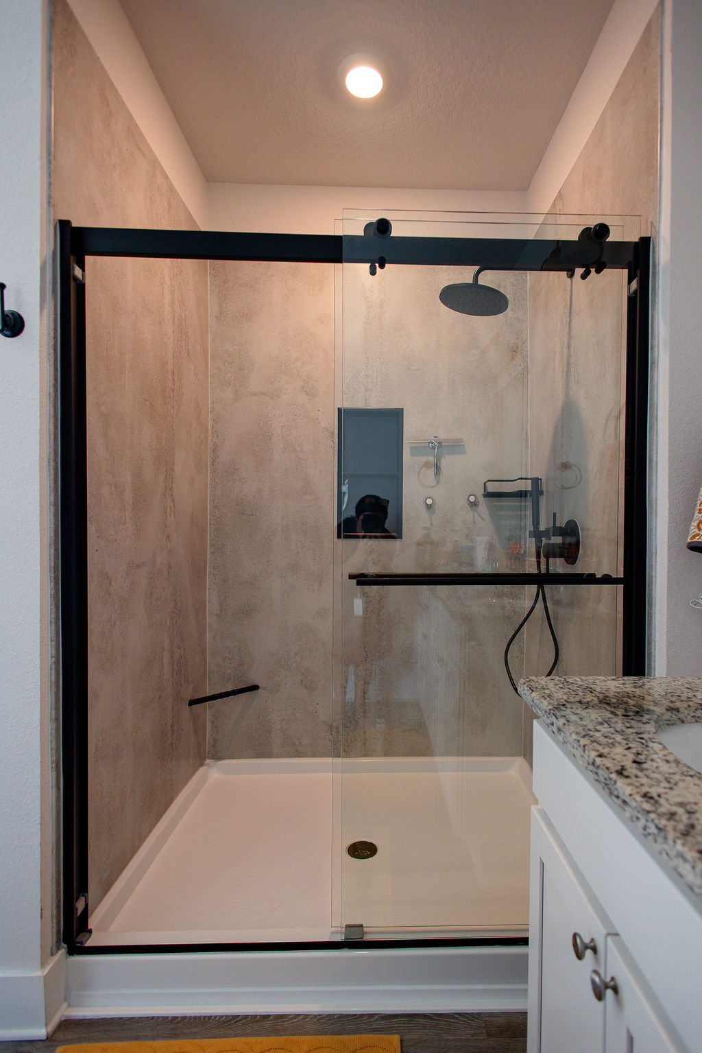 LatashaCarrawayPhotographyO’BRIEN-1311 new walk-in shower with rainfall shower head, storage cubby, corner shelving, and foot rest.